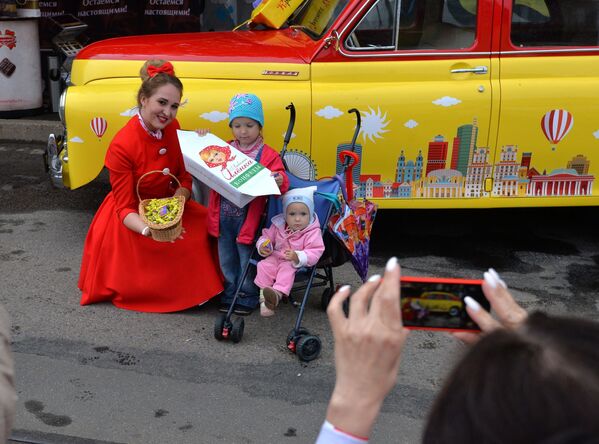 Детей на Октябрьской угощали конфетами и фотографировали на фоне ярких ретроавтомобилей. - Sputnik Беларусь