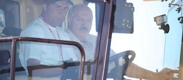 Президент Беларуси Александр Лукашенко за рулем комбайна Палессе GS2124 - Sputnik Беларусь