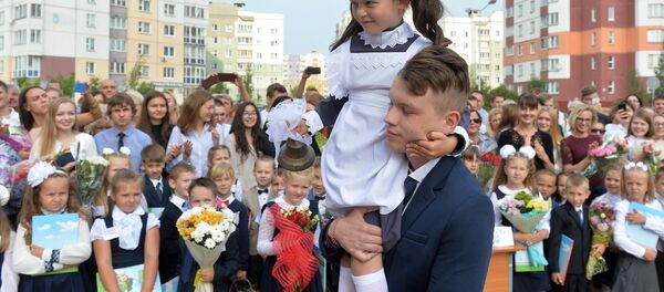 Традиция школьных линеек: 11-классник несет первоклассницу, которая звенит в колокольчик - в знак начала учебы. Традиция школьных линеек: 11-классник несет первоклассницу, которая звенит в колокольчик - в знак начала учебы. - Sputnik Беларусь