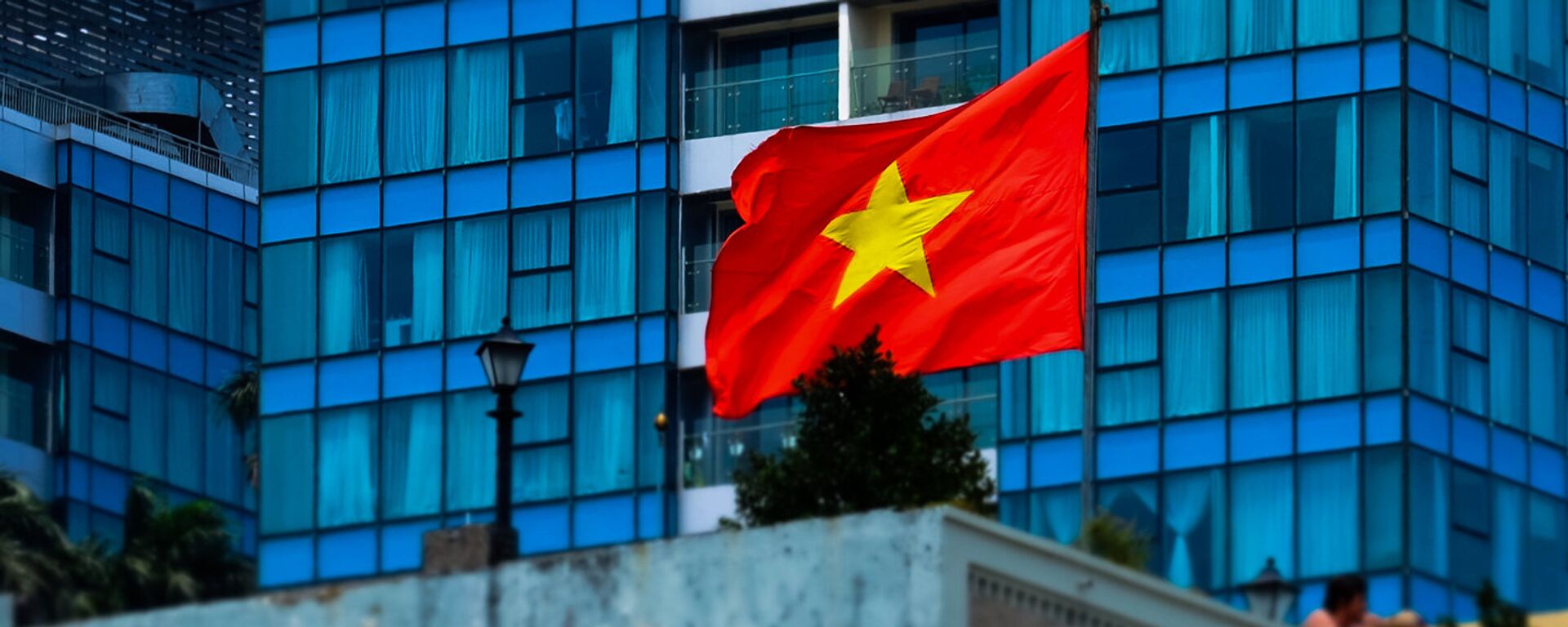 Флаг Дэмакратычнай Рэспублікі В'етнам на адным з будынкаў у Хашыміне - Sputnik Беларусь, 1920, 08.12.2023