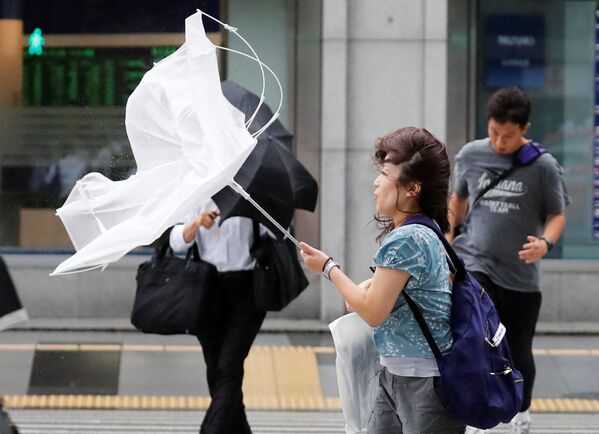 Пешеход с зонтом спасается от сильного ветра, вызванного тайфуном Джеби, Токио - Sputnik Беларусь