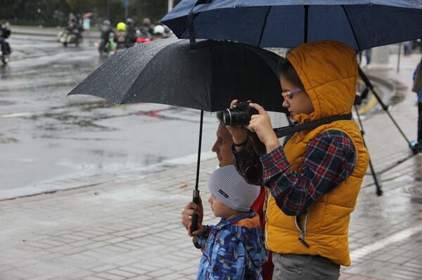 Несмотря на погоду, многие пришли на круглую площадь понаблюдать за тем, как проедет колонна - Sputnik Беларусь