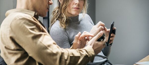 Мужчина и женщина с мобильными телефонами, архивное фото - Sputnik Беларусь