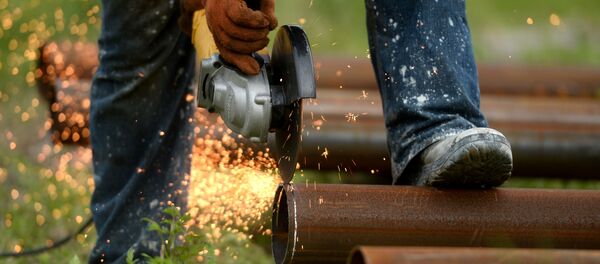 Рабочий обрабатывает водопроводную трубу для установки в скважину Рабочий обрабатывает водопроводную трубу для установки в скважину - Sputnik Беларусь