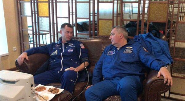 Член основного экипажа МКС-57/58 астронавт NASA Ник Хейг (США) проходит обследование после аварийной посадки в степи Казахстана. Справа - генеральный директор ГК Роскосмос Дмитрий Рогозин - Sputnik Беларусь
