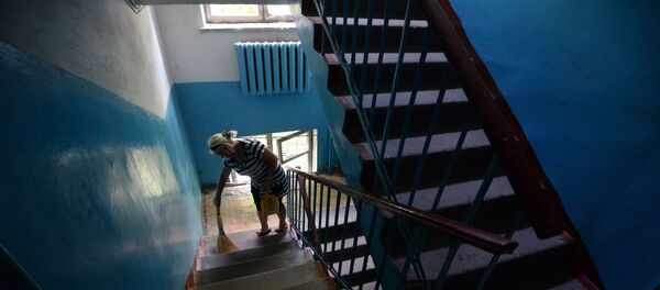 Жительница многоквартирного дома  убирается на лестничной площадке - Sputnik Беларусь