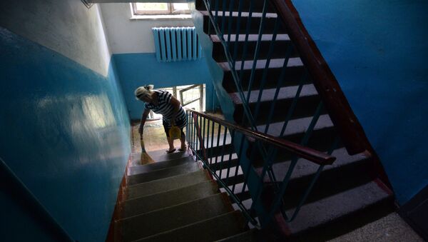 Жительница многоквартирного дома  убирается на лестничной площадке - Sputnik Беларусь