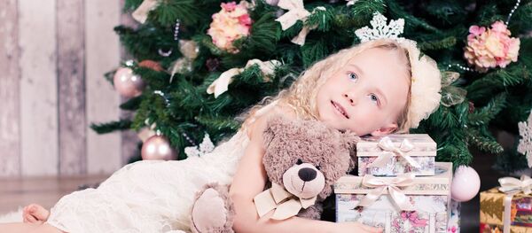 Ребенок с подарками у новогодней елки - Sputnik Беларусь