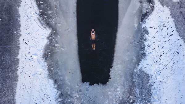 Человек плавает в частично замерзшем озере в Шэньяне, провинция Ляонин - Sputnik Беларусь