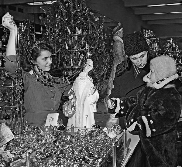 Папа с маленькой дочкой выбирают елочные украшения в магазине Детский мир в Москве в 1958 году. - Sputnik Беларусь