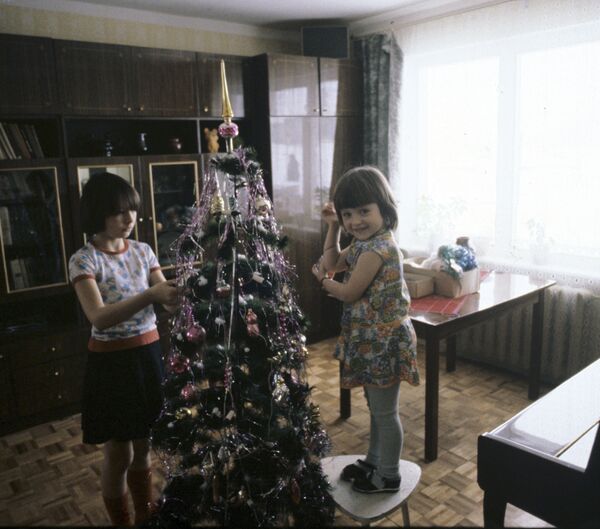 Дети наряжают новогоднюю елку, 1983 год. Многие, кто вырос в те годы, хранят новогодние игрушки из детства и даже вешают их теперь на елку. - Sputnik Беларусь