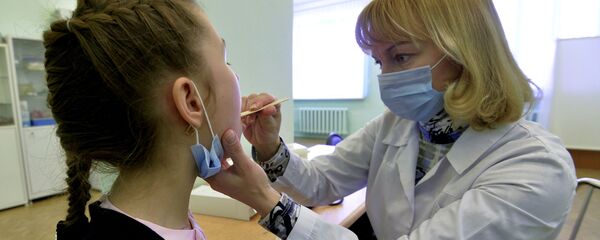 Урач гімназіі аглядае вучаніцу Урач гімназіі аглядае вучаніцу - Sputnik Беларусь