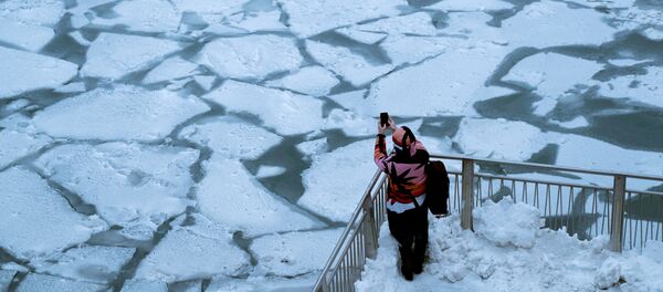 Девушка фотографирует реку Чикаго, после того, как на центральную и восточную часть США обрушился полярный вихрь - Sputnik Беларусь