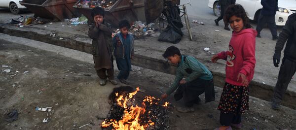 Афганские дети сжигают мусор, чтобы согреться, на обочине дороги в столице Афганистана Кабуле - Sputnik Беларусь