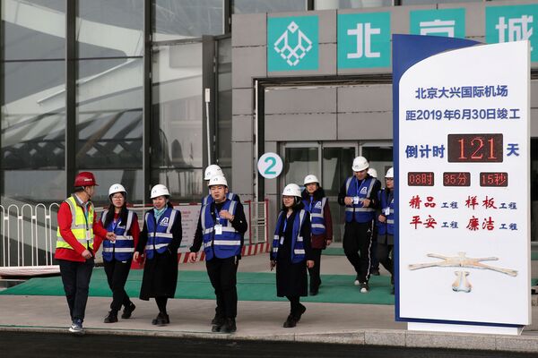 Посетители рядом с экраном, показывающим обратный отсчет до завершения строительства международного аэропорта Пекин Дасин - Sputnik Беларусь