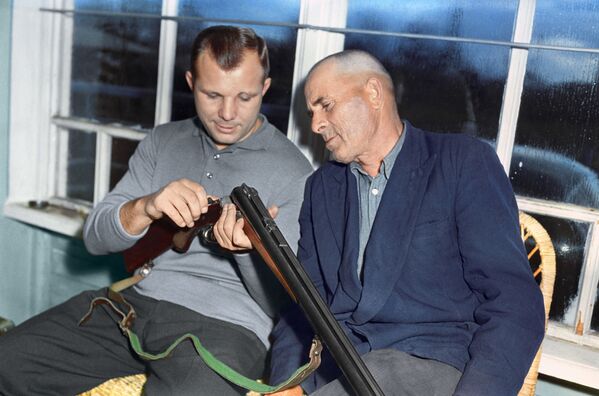 Отец и сын Гагарины рассматривают охотничье ружье. - Sputnik Беларусь
