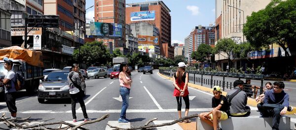Люди блокируют одну из улиц, чтобы показать недовольство из-за продолжающегося отключения электроэнергии в Каракасе - Sputnik Беларусь