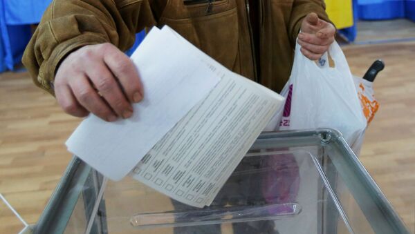 Мужчина бросает бюллетень в урну во время голосования на выборах президента Украины - Sputnik Беларусь