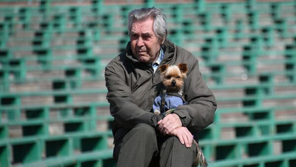 Мужчина с собачкой сидит на игровой площадке  - Sputnik Беларусь