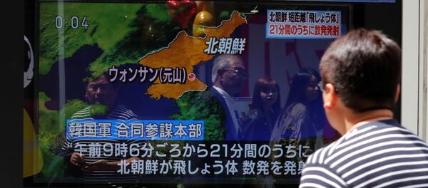 Японец смотрит репортаж о пуске ракет малой дальности КНДР - Sputnik Беларусь