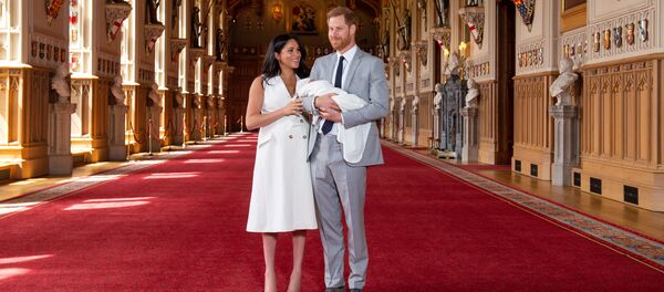 Меган Маркл в белом платье и на шпильках стояла рядом, приобнимая мужа и поглаживая ребенка - Sputnik Беларусь
