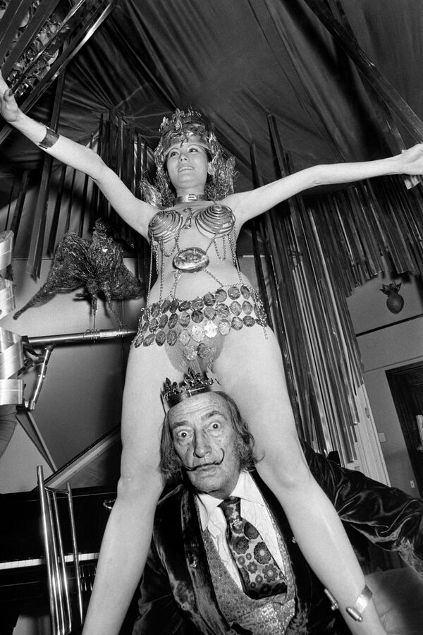Сальвадор Дали празднует день Богоявления вместе с девушкой в украшениях дизайнера Жана Шенафа 3 февраля 1972 года в своей резиденции в отеле Meurice в Париже. - Sputnik Беларусь