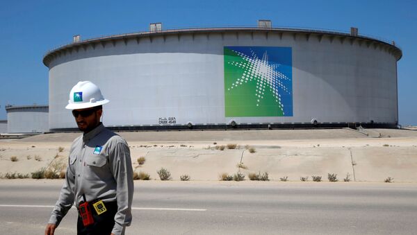 Сотрудник Aramco ходит рядом с резервуаром для нефти на нефтеперерабатывающем заводе Saudi Aramco - Sputnik Беларусь