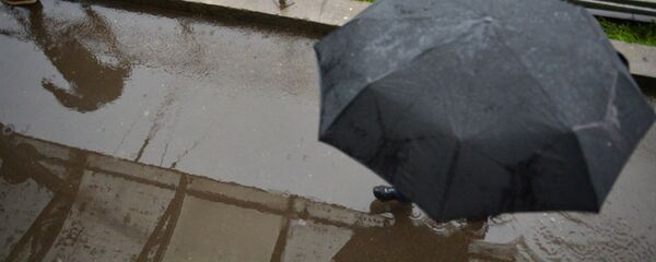 Прохожий под зонтом во время дождя - Sputnik Беларусь