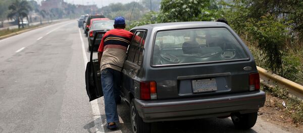 Водитель толкает автомобиль на АЗС Водитель толкает автомобиль на АЗС - Sputnik Беларусь