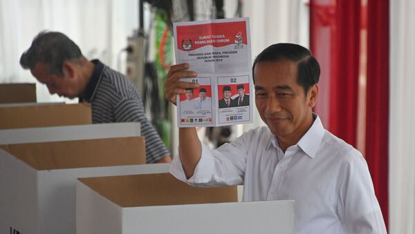 Действующий президент Джоко Видодо показывает избирательный бюллетень в избирательном центре во время президентских и законодательных выборов в Джакарте 17 апреля 2019 года - Sputnik Беларусь