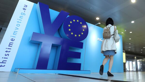 Женщина проходит мимо рекламного щита о выборах в ЕС - Sputnik Беларусь