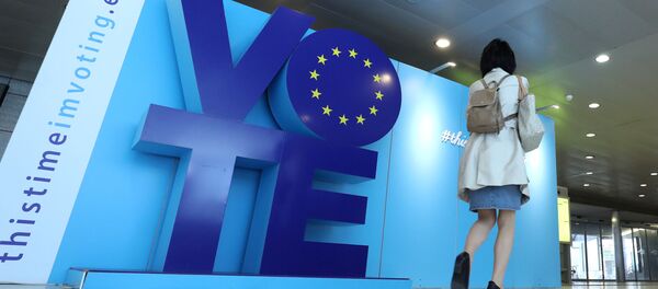 Женщина проходит мимо рекламного щита о выборах в ЕС - Sputnik Беларусь