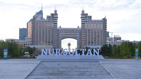 Надпись Nursultan в парке Гашиктар на фоне здания Национальной компании КазМунайГаз в Нур-Султане - Sputnik Беларусь
