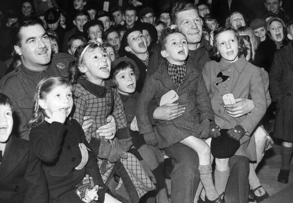 Канадские солдаты, дислоцированные на юге Англии, на вечеринке, организованной для местных детей. В канун Нового года, 31 декабря 1942-го, они смотрят кукольное шоу Панч и Джуди. - Sputnik Беларусь