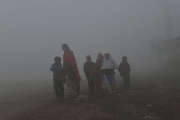 Матери ведут детей в школу вдоль дороги в условиях сильного тумана и смога в Лахоре - Sputnik Беларусь