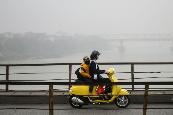 Женщина с ребенком в масках для лица едут по мосту среди смога над Ханоем - Sputnik Беларусь