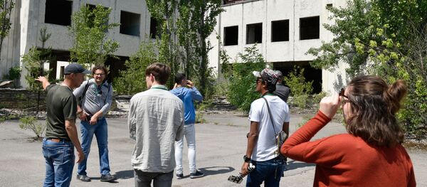 Туристы на экскурсии в зону отчуждения Чернобыльской атомной электростанции (ЧАЭС) в городе Припять (Украина) - Sputnik Беларусь