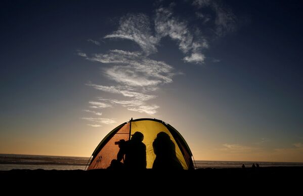 Туристы в палатке на пляже города Ла-Серена накануне затмения - Sputnik Беларусь