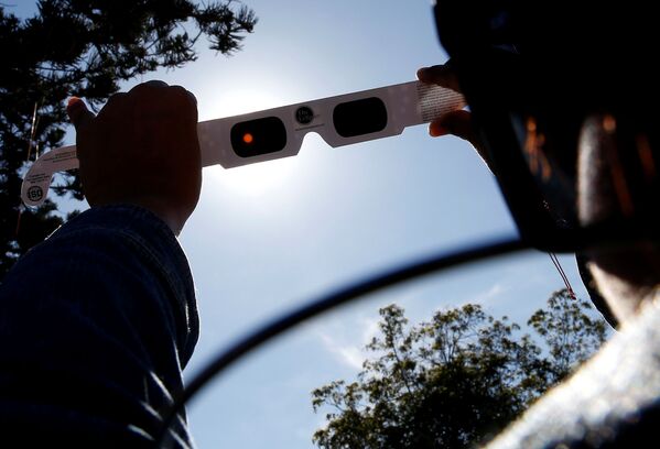 Женщина тестирует специальные очки для наблюдения за солнечным затмением в Кокимбо, Чили - Sputnik Беларусь