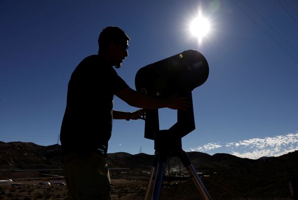 Мужчина готовится наблюдать за Солнцем с помощью телескопа - Sputnik Беларусь