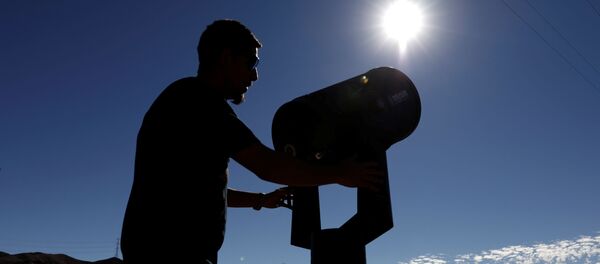 Мужчина готовится наблюдать за Солнцем с помощью телескопа - Sputnik Беларусь