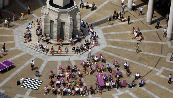 Люди сидят на шезлонгах во время обеденного перерыва, наслаждаясь жаркой погодой в Лондоне - Sputnik Беларусь