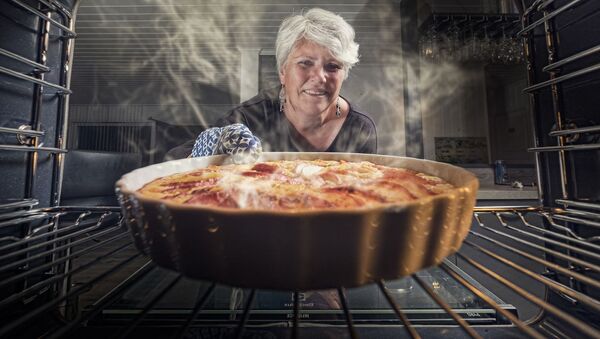 Женщина достает пирог из духовки - Sputnik Беларусь