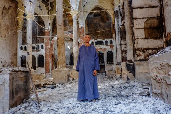 Копт в одной из сожженных и разрушенных коптских церквей в провинции Минья - Sputnik Беларусь