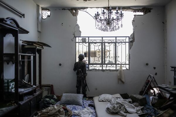 Военнослужащий сирийской правительственной армии в одном из захваченных домов - Sputnik Беларусь