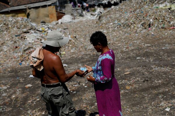 Местная жительница получает деньги после выгрузки мусора в ее родной деревне Бангун, Индонезия - Sputnik Беларусь