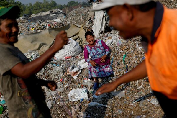 Местные жители рядом с грудами мусора в деревне Багун в Индонезии - Sputnik Беларусь