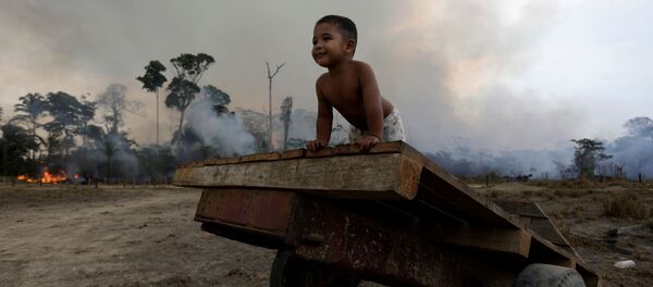 Ребенок играет во время природного пожара в лесах Амазонии  - Sputnik Беларусь