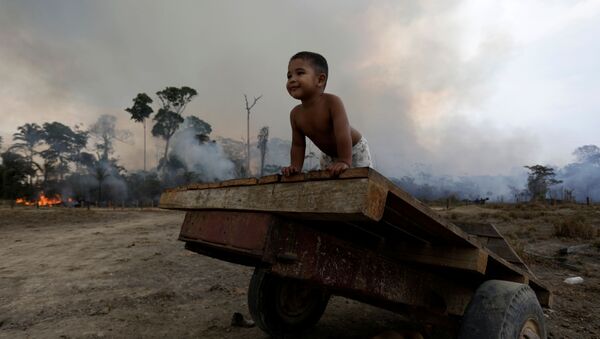 Ребенок играет во время природного пожара в лесах Амазонии  - Sputnik Беларусь