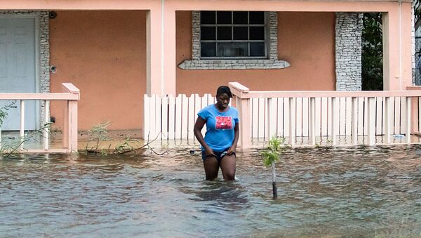 Женщина идет по затопленной улице после  урагана Дориан на Багамах - Sputnik Беларусь